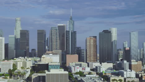 Panning-aerial-view-of-Los-Angeles-skyline-during-daytime,-capturing-the-vibrant-cityscape-and-urban-sprawl