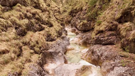 Aerial-view-of-the-Almbachklamm-waterfall-in-Garmisch-Partenkirche-during-summer-showcases-the-vibrant-display-of-colorful-foliage