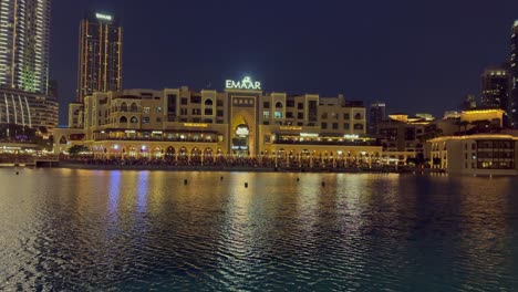 Lights-from-Emaar-Market-building-illuminate-Burj-Khalifa-Lake,-Dubai