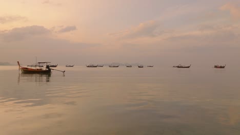 4K-aerial-drone-footage-of-Long-Tail-Boats-in-Thailand,-during-a-sunrise,-Asia