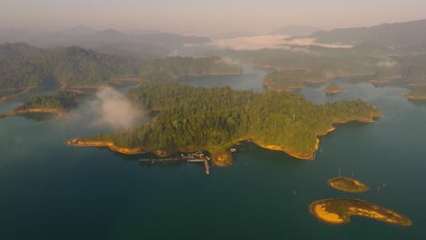 4K-Luftaufnahmen-Von-Schwebenden-Räumen-Im-Kao-Sok-Nationalpark-Bei-Sonnenaufgang,-See-Und-Bergen,-Thailand,-Asien