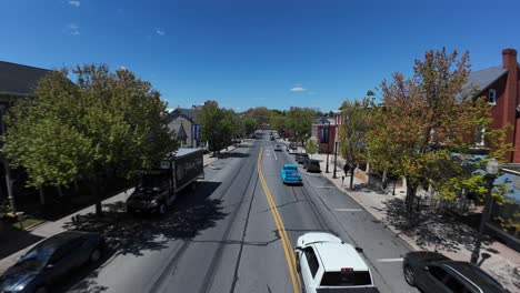 Turquoise-transfer-truck-on-main-street-of-American-town-during-sunny-day