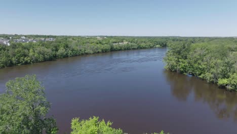 Moving-aerial-shot-capturing-natural-beauty-of-a-tropical-forest-with-Mississippi-river-dividing-them-in-Minnesota,-USA