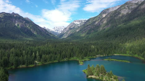 Aerial-Journey-Pan-Left-Over-Turquoise-Lake-and-Evergreen-Trees