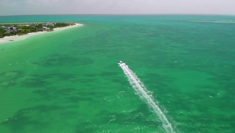 Vista-Aérea-De-Una-Lancha-Rápida-Navegando-Por-Aguas-Tropicales,-Dejando-Un-Rastro-De-Estela