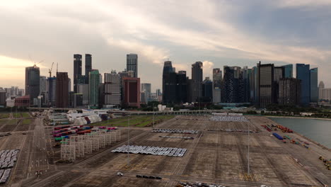 Flotte-Von-Autos-Geparkt-Auf-Dem-Großen-Hafenterminal-Von-Singapur-Mit-Blick-Auf-Die-Skyline,-Drohne