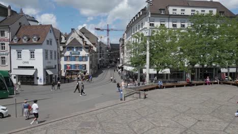 4K-Drohnenvideo-Von-Fußgängern,-Fahrrädern-Und-Zügen-In-Der-Nähe-Eines-Zugdepots-In-Basel,-Schweiz