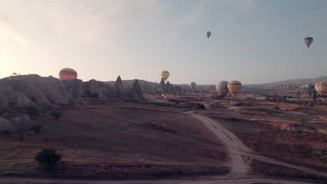 Drohne-Fliegt-Durch-Felsöffnung-Und-Enthüllt-Kappadokiens-Ballons