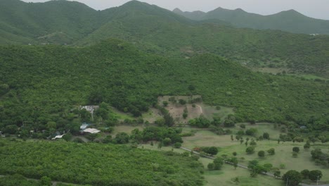 Drone-view-of-Loterie-farm-surrounded-by-greenery-at-Saint-Martin-on-a-cloudy-day