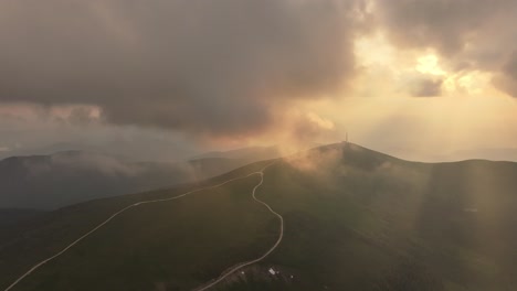 Immerse-yourself-in-a-breathtaking-drone-view-of-a-sunset-draped-in-clouds,-where-vibrant-hues-blend-with-the-soft,-textured-sky,-creating-a-dramatic-and-serene-landscape