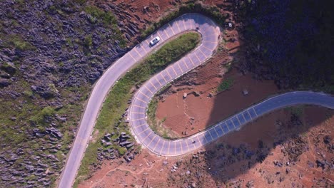 This-drone-footage-captures-a-stunning-aerial-view-of-a-winding-road-in-Ha-Giang,-North-Vietnam