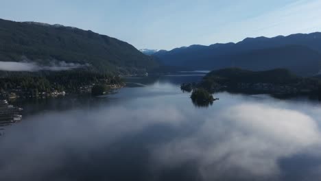 A-drone-shot-flying-through-a-cloud-revealing-a-vast-fjord-below-in-Vancouver-British-Columbia