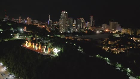 Letrero-De-La-Ciudad-De-Pattaya,-Tailandia,-Iluminado-Por-La-Noche,-Imágenes-Aéreas-De-Drones