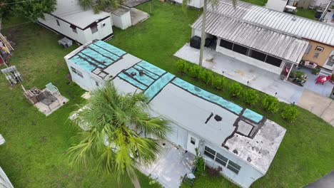 Blue-tarp-on-mobile-home,-double-wide-roof-after-hurricane-in-southern-USA