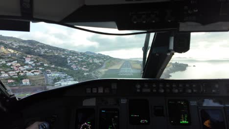 Immersive-pilot-perspective-in-a-real-time-landing-at-dangerous-Madeira-Funchal-airport-in-Portugal,-in-a-windy-and-cloudy-day