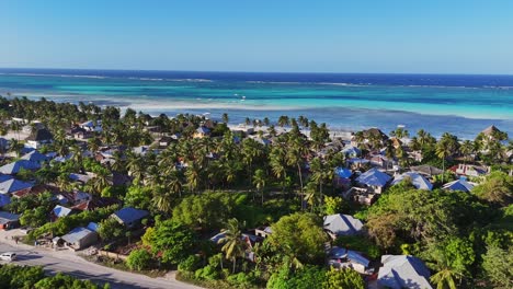 Panoramic-aerial-of-Pingwe-village-and-Indian-Ocean's-turquoise-waters,-Zanzibar-island,-Tanzania