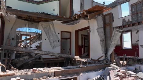 Aerial-approaching-shot-of-destroyed-demolished-single-family-house-in-sunlight