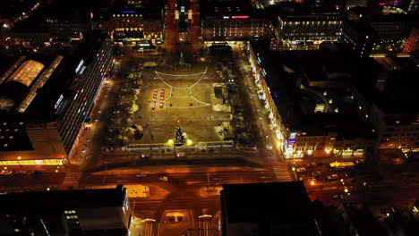 Drohne-Neigt-Sich-Vom-Nachts-Beleuchteten-Marktplatz-Von-Vaasa-Weg,-Winter-In-Finnland