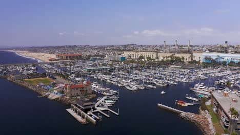 Aerial-low-panning-shot-of-the-King-Harbor-Marina-towards-Hermosa-Beach-in-Redondo-Beach,-California