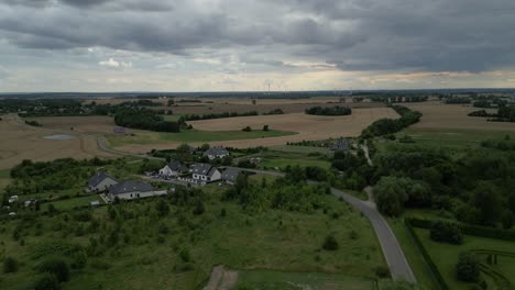 Pueblo-Rural-Con-Granja-De-Energía-Eólica-Al-Fondo-Durante-Un-Día-Nublado-En-Polonia