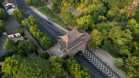 Una-Impresionante-Toma-Aérea-De-Una-Antigua-Puerta-En-Wuhan,-Yuxtapuesta-Con-Una-Carretera-Moderna.