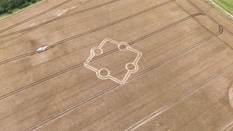 Stone-henge-square-crop-circle-formation-aerial-view-circling-above-golden-farmland-field-design