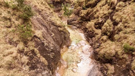 Aerial-view-of-the-Almbachklamm-waterfall-in-Garmisch-Partenkirche-during-summer-showcases-the-vibrant-display-of-colorful-foliage