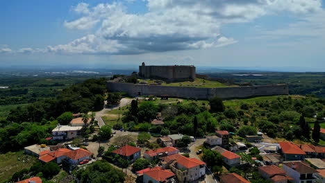 Seitenansicht-Des-Chlemoutsi-Schlossmuseums-Auf-Einem-Hügel-Neben-Der-Stadt-Mit-Den-Roten-Dächern,-Griechenland,-Zeitlupe-Und-Kopierraum