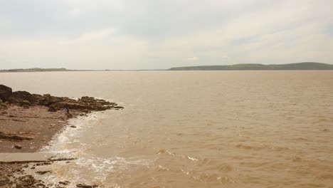 Calm-shoreline-with-gentle-waves-under-a-partly-cloudy-sky