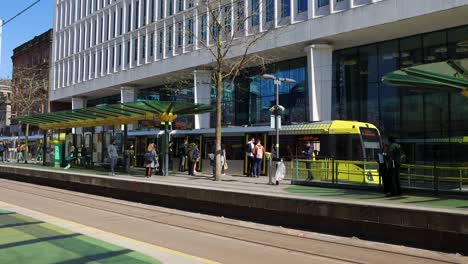 Yellow-tram-stopping-in-downtown-Manchester-city-on-sunny-day