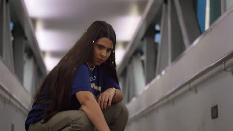 A-young-Latina-in-stylish-streetwear-enjoys-a-scenic-pedestrian-overpass-in-Port-of-Spain,-Trinidad