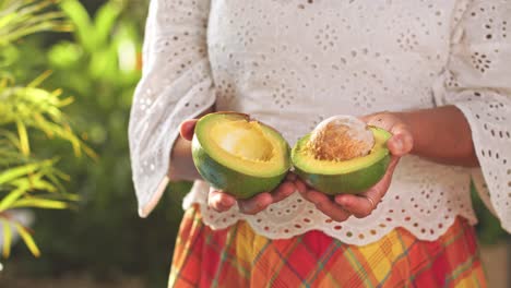 Manos-Femeninas-Abriendo-Aguacate-Por-La-Mitad-Y-Mostrándolo-A-La-Cámara