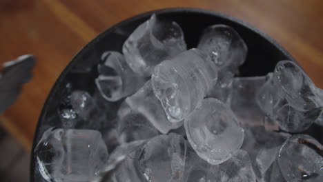 Beautiful-close-up-shot-of-tongs-picking-up-an-ice-cube-to-prepare-a-cocktail-called-piña-colada,-popular-in-Latin-America-and-the-Caribbean