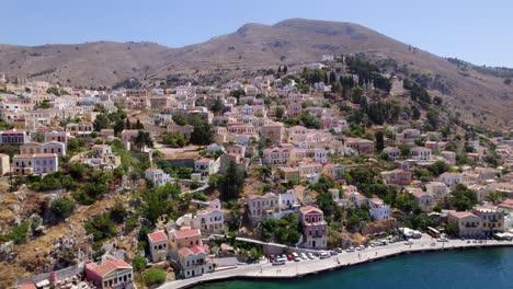 Atemberaubende-Luftaufnahmen-Einer-Griechischen-Insel-Mit-Bunten-Häusern,-Bergen-Und-Meerblick