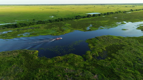 Luftaufnahme-über-Menschen-Auf-Einer-Bootsfahrt-Auf-Dem-Fluss-Los-Llanos-In-Venezuela-Bei-Sonnenuntergang---Drohnenaufnahme