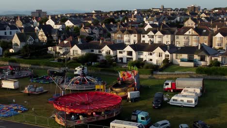 Vibrant-fairground-rides-aerial-view-circling-Holyhead-Welsh-coastal-town-waterfront-entertainment