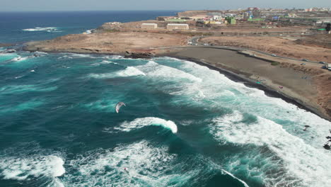 Aerial-view-over-La-Restinga-beach-and-people-kitesurfing-on-a-windy-and-sunny-day