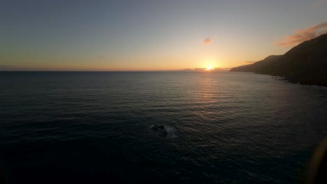 Vista-Aérea-Ascendente-De-La-Puesta-De-Sol-Sobre-El-Océano-En-La-Isla-De-Madeira,-Portugal