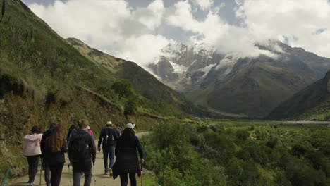 Tourists-walking-to-Humantay-Lake-with-Salkantay-mountain-in-background,-Cusco-Peru