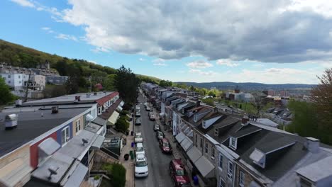 Dense-populated-neighborhood-with-parking-cars-in-narrow-street-during-spring-season