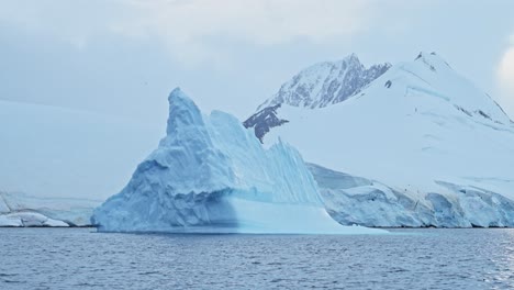 Calentamiento-Global-Del-Mar-Y-El-Océano-En-La-Antártida-Con-Paisaje-De-Montañas-Y-Icebergs,-Cambio-Climático-Con-Calentamiento-Del-Agua-En-Una-Hermosa-Y-Espectacular-Escena-Invernal-En-La-Península-Antártica