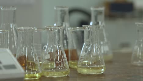 Pan-to-a-close-up-shot-of-conical-flasks,-which-has-yellow-solution-in-them