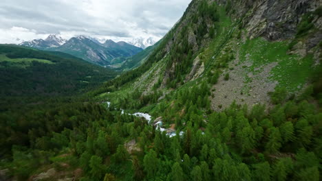 Cascadas-De-La-Cascada-Del-Rutor-En-Un-Exuberante-Valle-Verde-Rodeado-De-Montañas,-Vista-Aérea