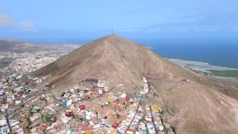 Aerial-view-of-Galdar-town-city-village-under-the-mountain-against-seascape-in-Gran-Canaria,-Spain