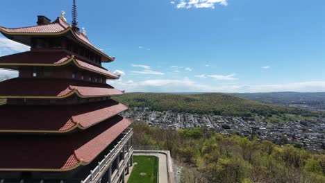 FPV-flight-along-Pagoda-Building-on-mountaintop-during-sunny-day-with-blue-sky