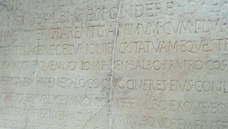 Ancient-Roman-Latin-text-chiseled-into-a-white-marble-slab-from-the-historic-town-of-Herculaneum-in-Naples,-Italy