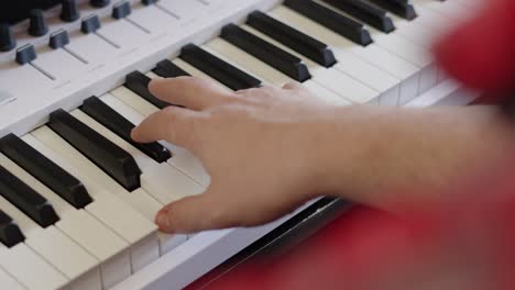 Over-The-Shoulder-View-of-Male-Hands-Playing-Keyboard-Piano-Notes-During-Studio-Music-Recording-Session