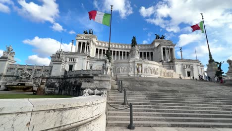 Italienische-Flaggen-Wehen-Außerhalb-Der-Piazza-Venezia,-Einem-Nationaldenkmal-In-Rom,-Italien,-Blick-Vom-Fuß-Der-Treppe