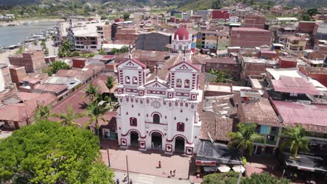 Aerial-panoramic-of-colorful-church-and-town-in-Guatapé,-Colombia