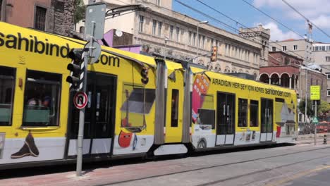 A-busy-street-with-moving-yellow-tram-and-cars-in-the-city-of-Istanbul